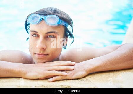 Ritratto di giovane uomo con capelli bagnati in piscina Foto Stock