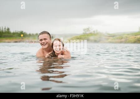 Coppia giovane in Laguna Segreta primavera calda (Gamla Laugin), Fludir, Islanda Foto Stock