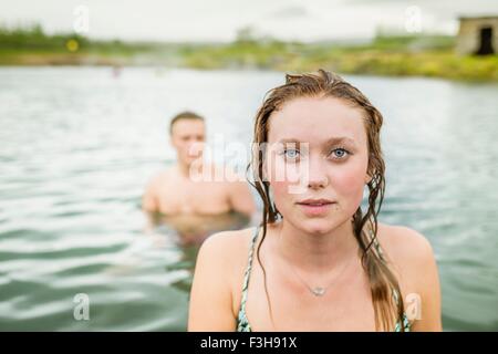 Ritratto di giovane donna in piedi nella parte anteriore del ragazzo in Laguna Segreta primavera calda (Gamla Laugin), Fludir, Islanda Foto Stock