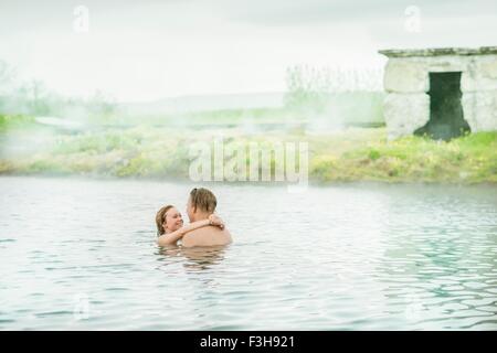 Romantico coppia giovane rilassante in Laguna Segreta primavera calda (Gamla Laugin), Fludir, Islanda Foto Stock