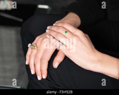 Le mani del gioielliere femmina indossando la varietà di anelli in gioielleria Foto Stock