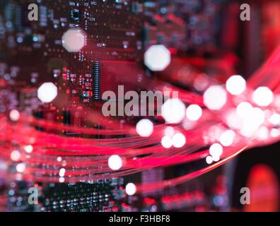 Le fibre ottiche che fluisce attraverso le schede di circuito da un computer portatile, close-up Foto Stock