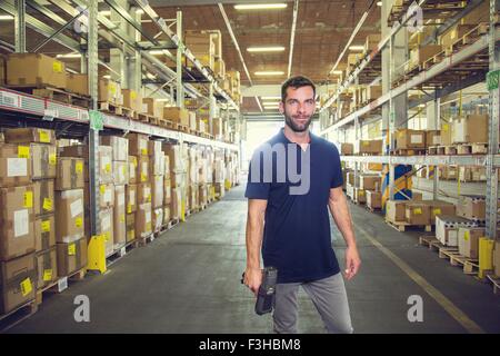 Ritratto di magazzino maschio lavoratore permanente di distribuzione nel corridoio magazzino Foto Stock