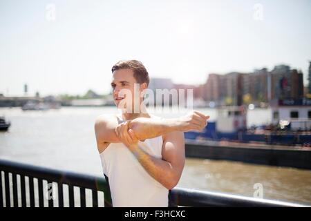 Runner stretching sul lungofiume, Wapping, Londra Foto Stock