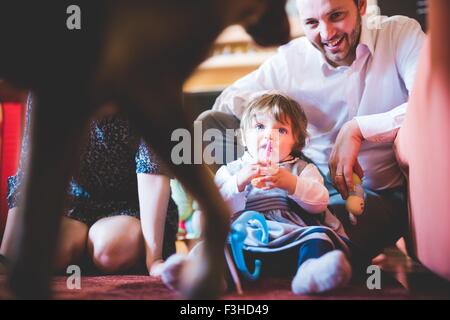 Femmina bambino seduto sul soggiorno piano guarda cane Foto Stock