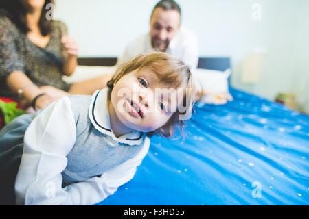 Ritratto di donna bambino con i genitori su letto Foto Stock