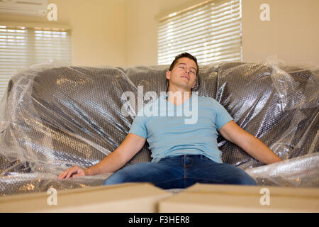 Giovane uomo spostare mobili a casa Foto stock - Alamy