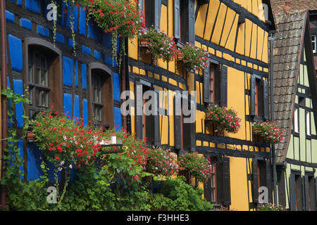 Metà colorati edifici con travi di legno Rue il generale de Gaulle Riquewihr Alsace Francia Foto Stock