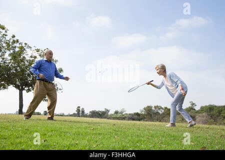 Coppia senior giocando badminton in posizione di parcheggio Foto Stock