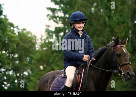 Ragazza passeggiate a cavallo nella campagna Foto Stock