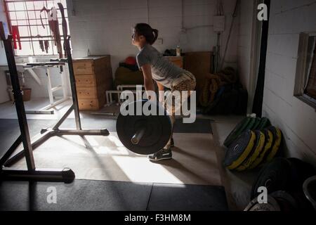 Sollevamento donna barbell in palestra Foto Stock