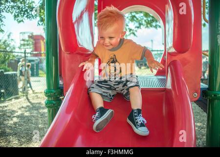 Un bambino gioca su red parco giochi slitta Foto Stock