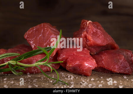 Materie di manzo con spezie su uno sfondo di legno Foto Stock