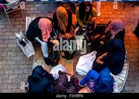 Giovani donne musulmane sedersi a chattare in un caffè di Carnaby Street, Londra, Regno Unito Foto Stock