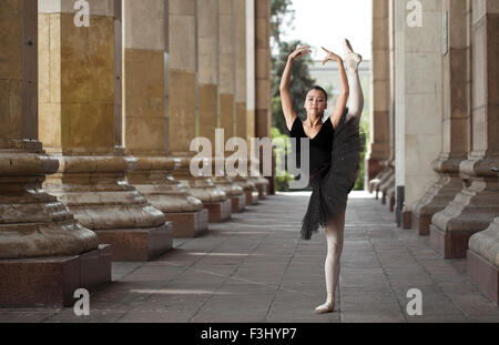 Ragazza ballerina flats permanente sulla tiptoes sulla strada Foto Stock