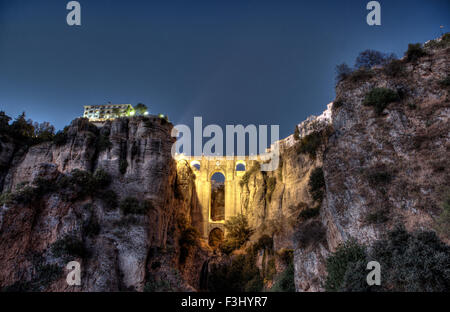 Illuminata Puente Nuevo ponte dalla periferia di Ronda al tramonto, Spagna. HDR Foto Stock