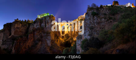 Illuminata Puente Nuevo ponte dalla periferia di Ronda al tramonto, Spagna. Vista panoramica Foto Stock