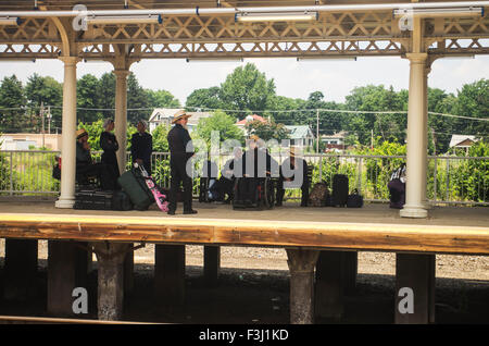 Pennsylvania Dutch gruppo su una piattaforma del treno vicino Pittsburgh, PA, uno in una sedia a rotelle Foto Stock