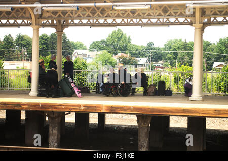 Pennsylvania Dutch gruppo su una piattaforma del treno vicino Pittsburgh, PA, uno in una sedia a rotelle Foto Stock