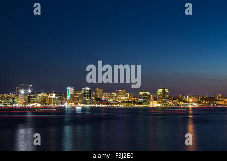 Una vista di Halifax Waterfront di notte. Il sentiero delle barche può essere visto nell'acqua. Foto Stock