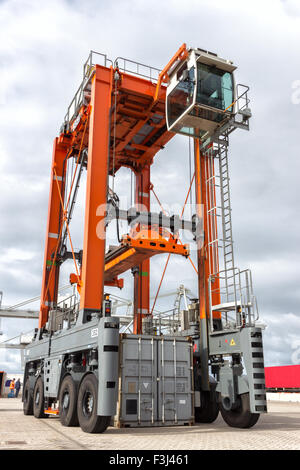 "Straddle carrier per la movimentazione di contenitori in un porto di spedizione. Foto Stock