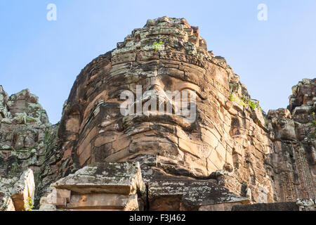 Uno del gigante di pietra si affaccia al tempio Bayon a Angkor Wat, Cambogia Foto Stock