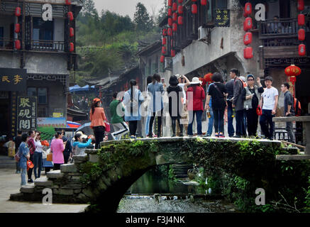 (151008) -- PECHINO, Ottobre 8, 2015 (Xinhua) -- i turisti stand sui Tongji Bridge, con una storia di più di cento anni, in Likeng antica città della contea di Wuyuan, Cina orientale della provincia di Jiangxi, 1 aprile 2015. (Xinhua/Wang Song) (wyo) Foto Stock