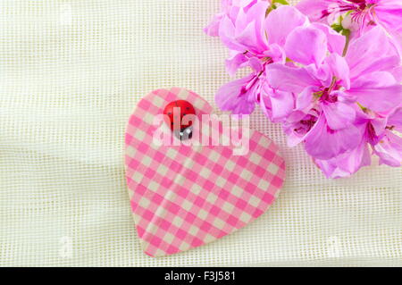 Carino forma di cuore con fiori di colore rosa sullo sfondo Foto Stock