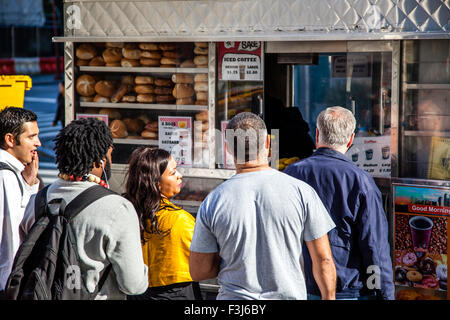 Persone in piedi in linea al food cart in New York City Foto Stock