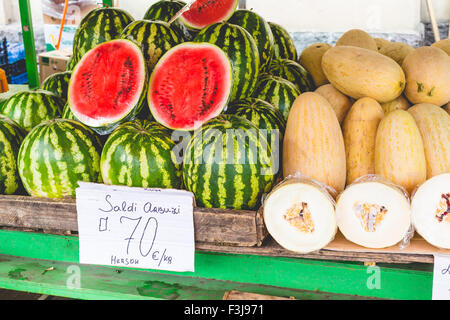 Molti grandi dolci verdi cocomeri e un taglio cocomero Foto Stock