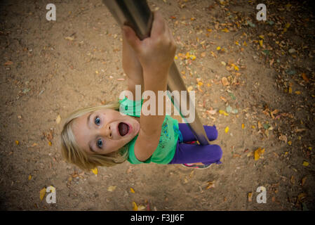 La ragazza del bambino si arrampica su un palo in corrispondenza del parco giochi, scorrevole, kid giocando Foto Stock