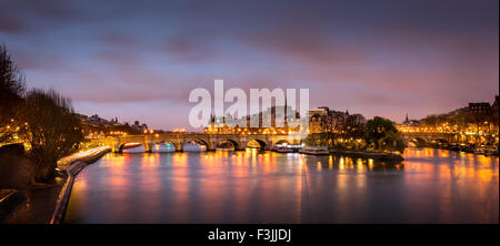 Sunrise nel cuore di Parigi, in Francia con Ile de la Cite e Pont Neuf. Un tranquillo Fiume Senna riflette le luci della citta'. Foto Stock