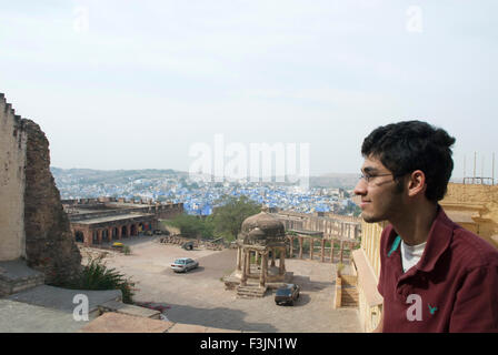 Ragazzo che guarda vista Mehrang Garh fort a Jodhpur ; Rajasthan ; India n. MR Foto Stock