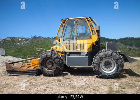 Trattore giallo per lavori stradali, vista laterale Foto Stock