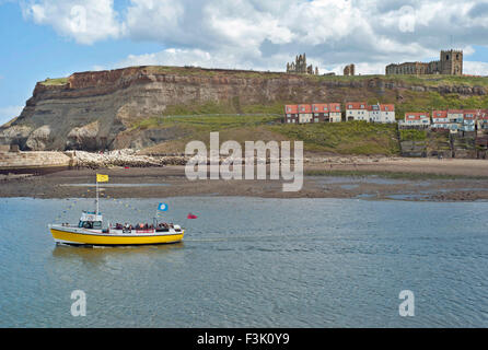 Whitby, North Yorkshire, imbarcazione da diporto in primo piano,Whitby Abbey si erge imponente su un promontorio che si affaccia sulla città marittima REGNO UNITO Foto Stock