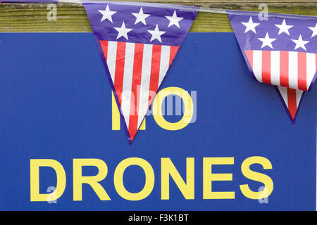Informazioni pubbliche segno 'No fuchi' con bandiera americana Bunting attaccato a una recinzione di legno Foto Stock
