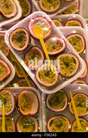 Pronto a mangiare il frutto della passione in un contenitore di polistirolo coperto con della pellicola trasparente Foto Stock