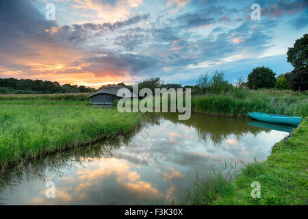 Tramonto mozzafiato su una barca e paglia boat house di reed sulla Norfolk Broads Foto Stock