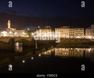 Guardando le riflessioni sul fiume Arno di notte, Firenze, Italia Foto Stock