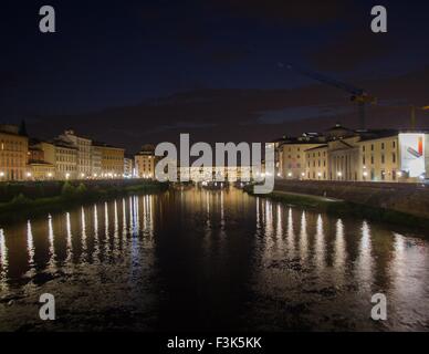 Guardando le riflessioni sul fiume Arno di notte, Firenze, Italia. Foto Stock