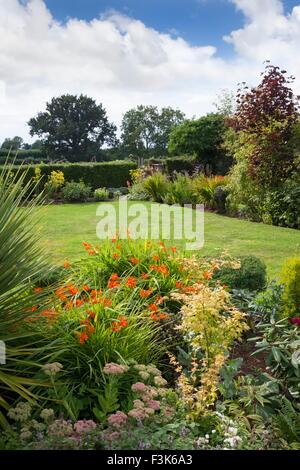 English Garden cottage in estate con fiori e prato. Foto Stock