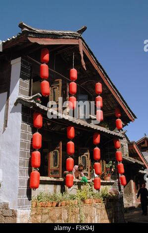 Lijiang, Cina: stringhe di colore rosso brillante lanterne cinesi appendere a partire da un tradizionale Naxi home Foto Stock