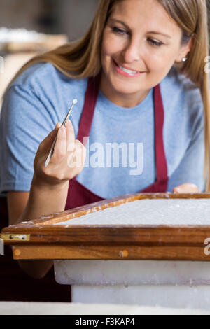Lavoratore rimozione di grandi di fibre della carta con le pinzette Foto Stock