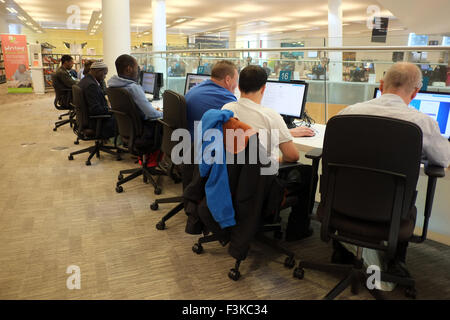 Un gruppo di persone che utilizzano il computer e laptop di connettersi ad internet nella biblioteca di Liverpool, Liverpool, Merseyside, Regno Unito Foto Stock