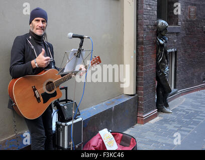 Suonare la chitarra   accattonaggio musicista di strada Busker in Matthew Street, Liverpool, Merseyside, Regno Unito Foto Stock