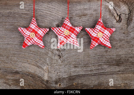 In tessuto rosso star Buon Natale decorazioni artigianali su rustico in legno di olmo di sfondo - stile retrò design, spazio di copia Foto Stock