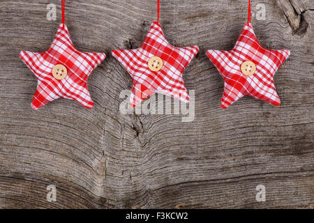 In tessuto rosso star Buon Natale decorazioni artigianali su rustico in legno di olmo di sfondo - stile retrò design, spazio di copia Foto Stock