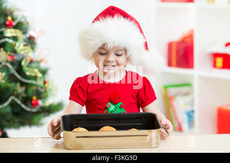 Kid ragazza in Santa hat holding biscotti di Natale Foto Stock