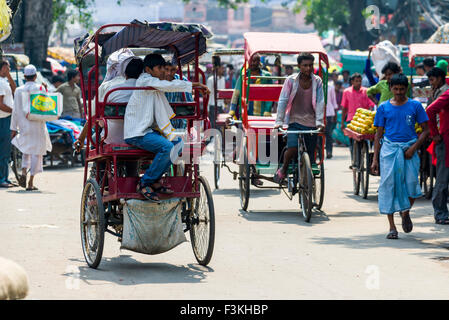 Molte persone e ciclo rikshaws si stanno spostando attraverso le strade del borgo La Vecchia Delhi Foto Stock