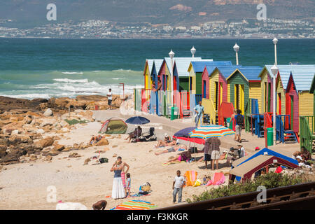 La popolazione locale sulla spiaggia con ombrelloni e colorate cabine, St. James Beach, Golfo Oceano, Sud Africa Foto Stock